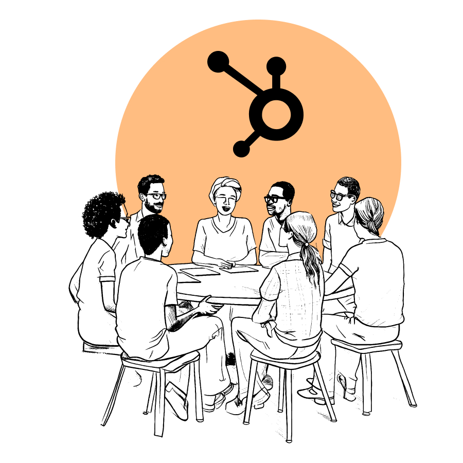 A group of people discussing HubSpot, smiling at their table