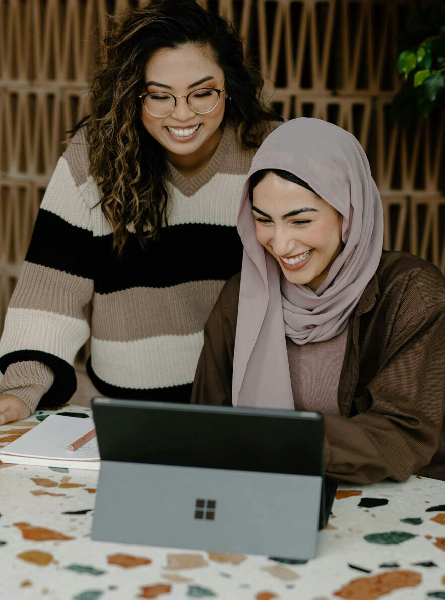 Two women smiling at laptop (1)